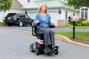 woman rides power wheelchair through neighborhood
