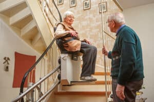 An elderly couple uses a Copper Star stair lift for greater independence