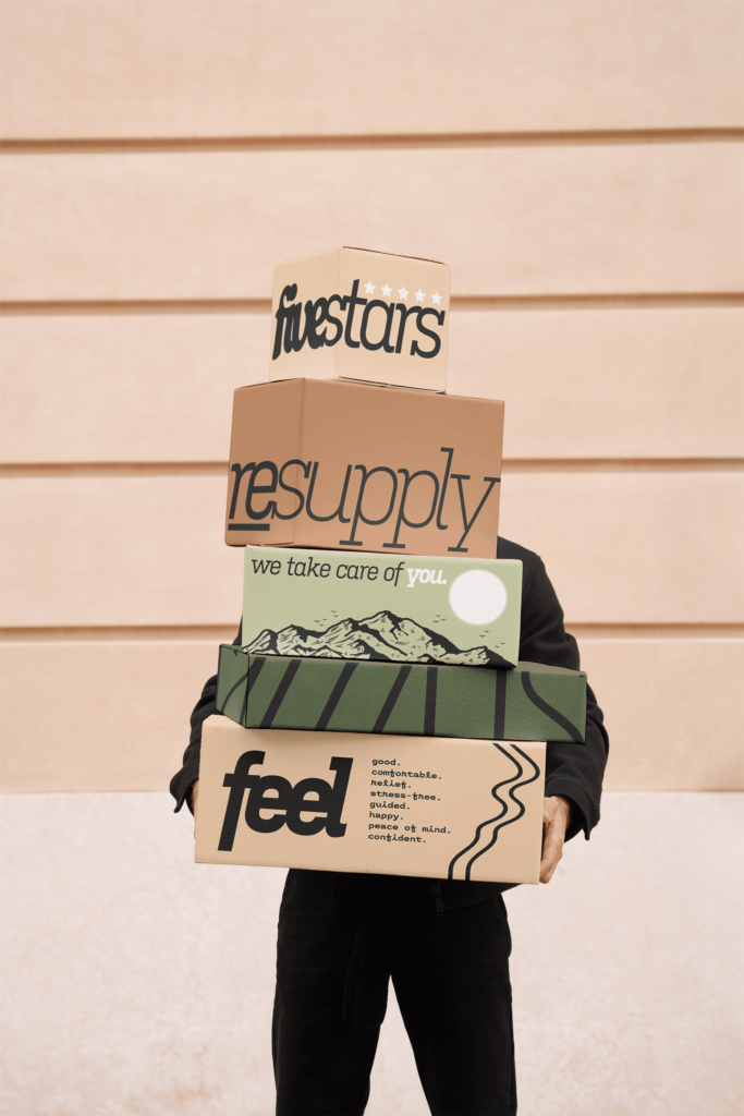 A person holding a stack of Resupply boxes.