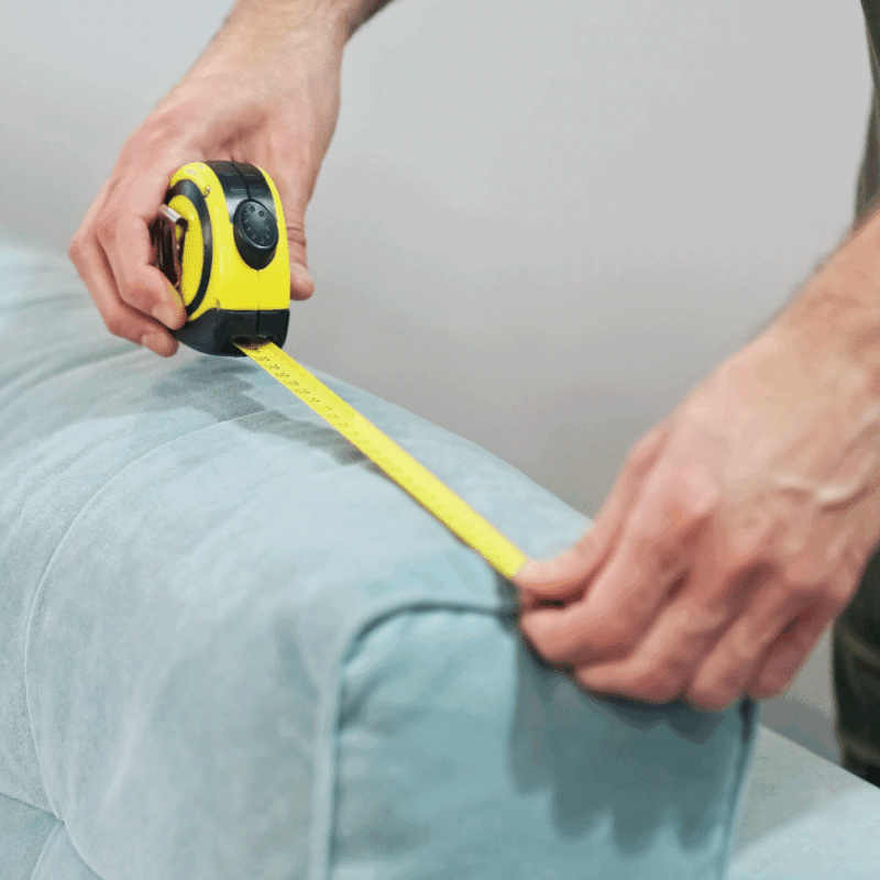 Person measuring a Lift Chair with a yellow tape measure