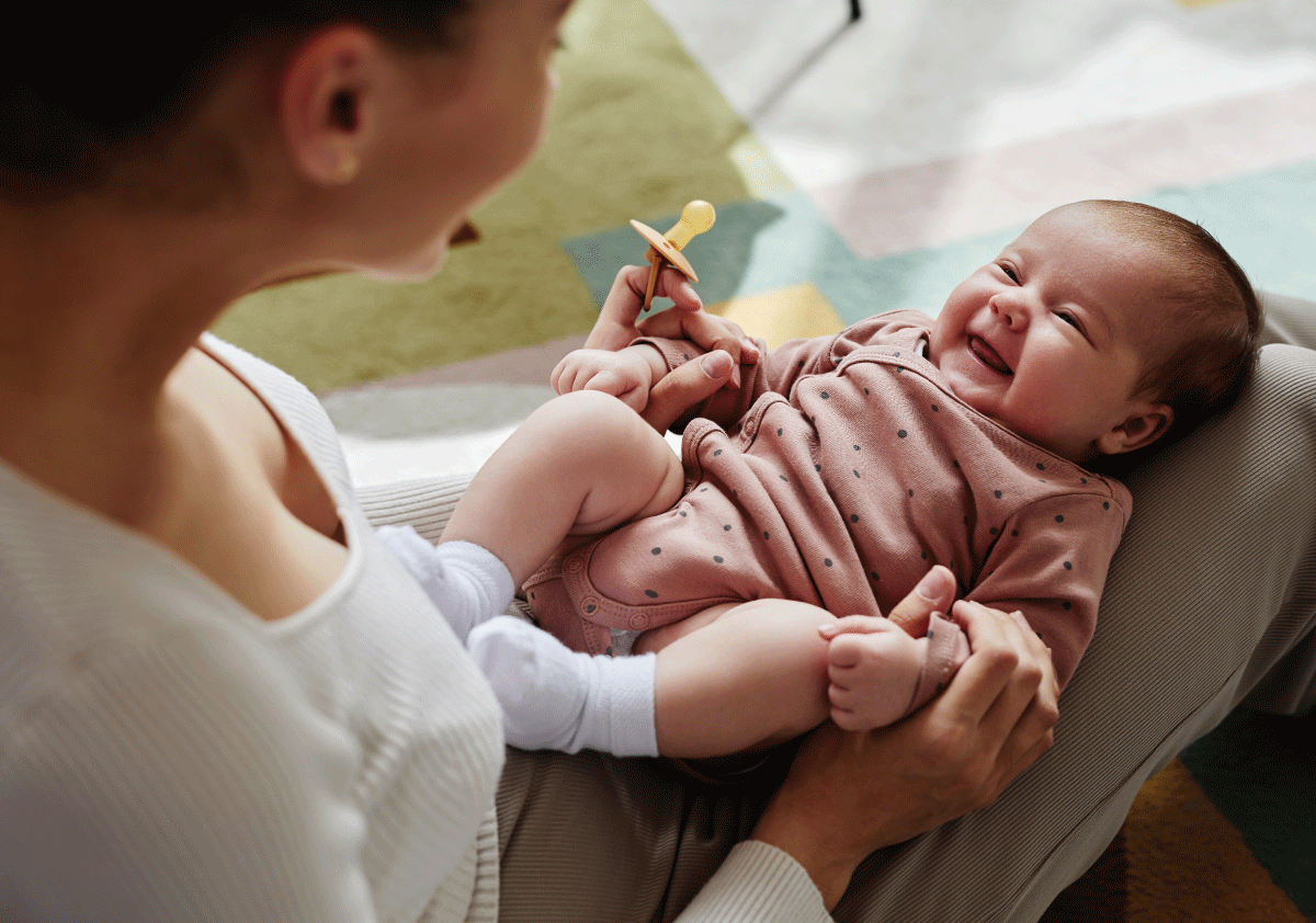 Smiling newborn baby with mother, representing breastfeeding and pumping support for new moms