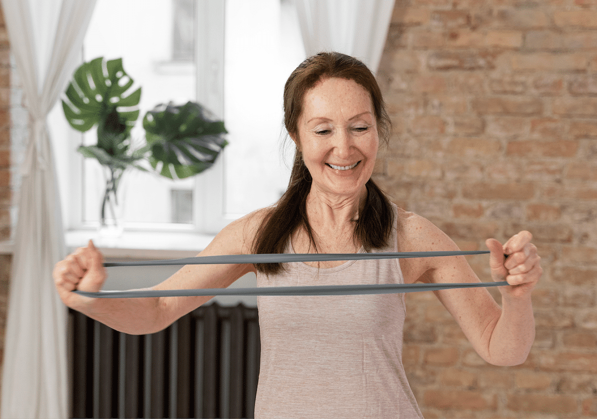 A woman using a resistance band for physical therapy at home